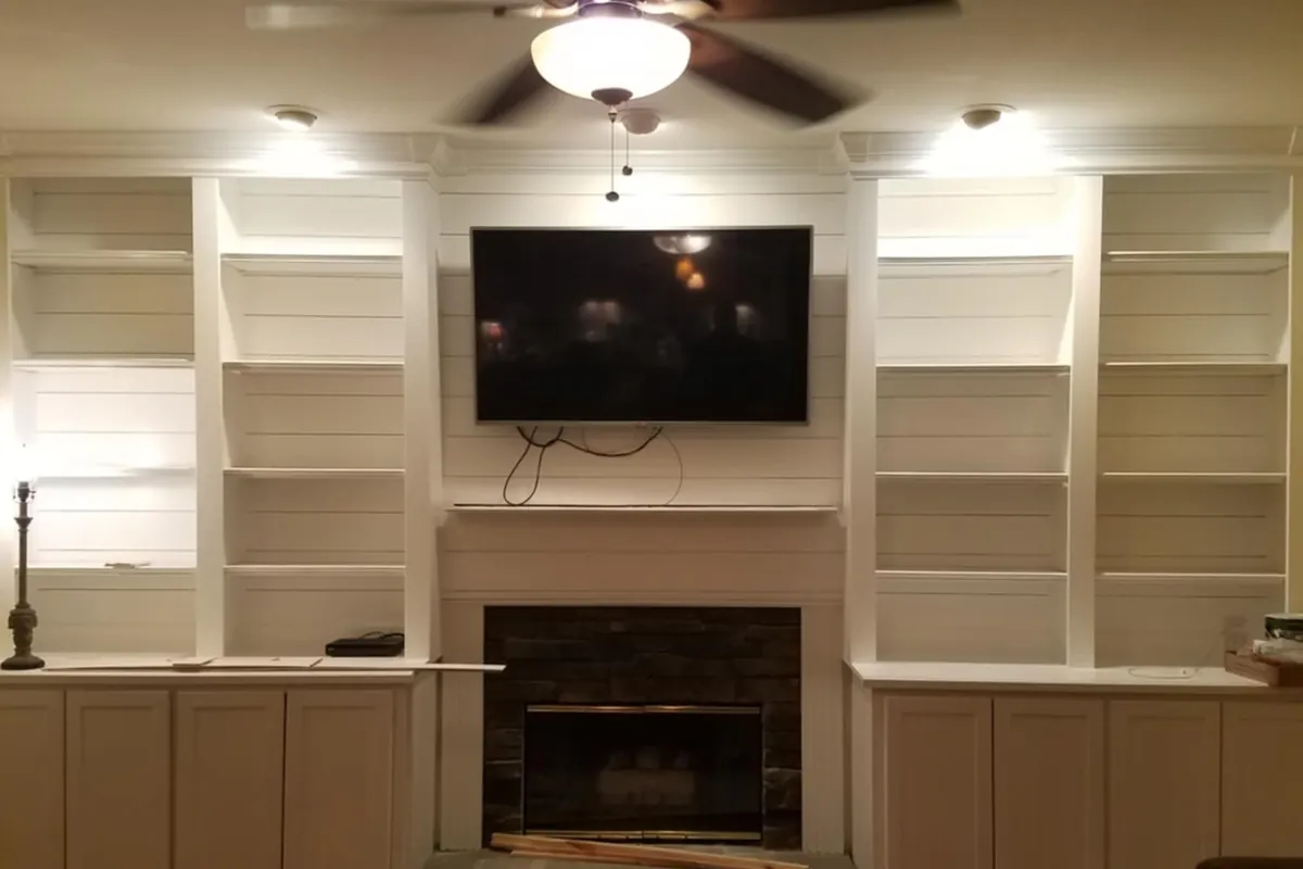A living room with custom built-in cabinetry and shelving flanking a fireplace